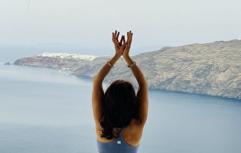 Woman practicing yoga overlooking the ocean