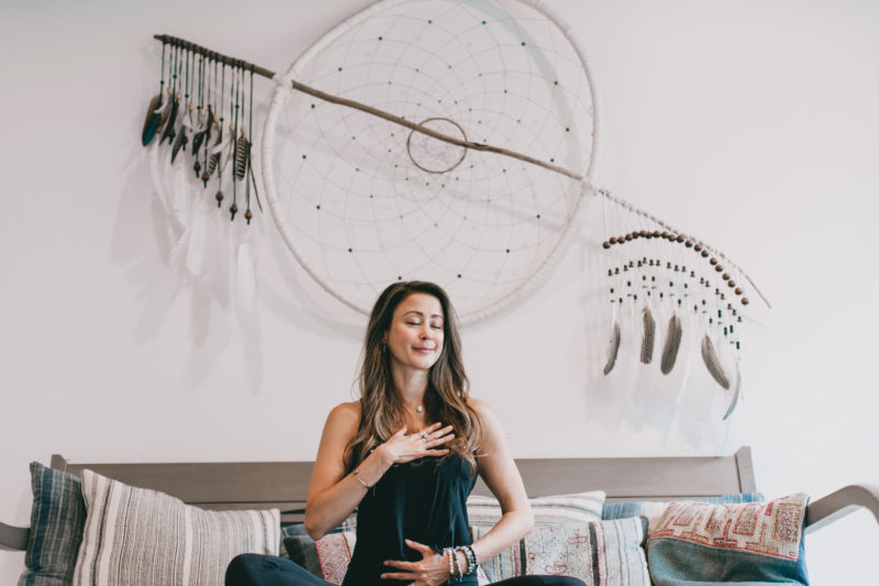 Woman in meditation with hand over heart